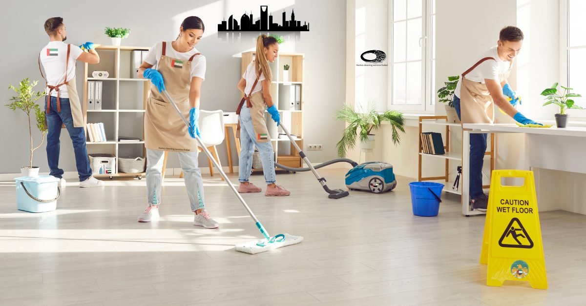Cleaning team mopping the floor and wiping desks during an office deep clean in Dubai, with a wet floor caution sign in view